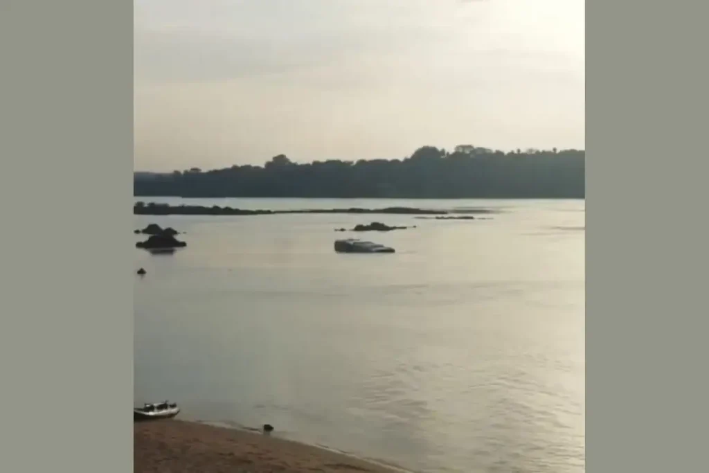 Destroços de ônibus parcialmente submerso no Rio Tocantins