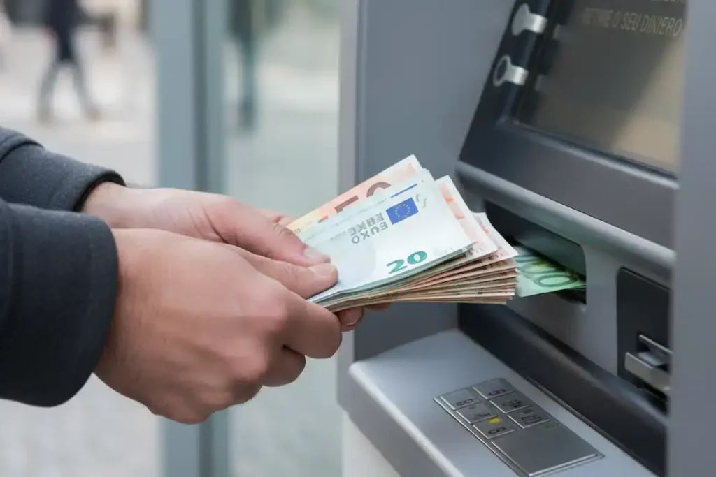 Correspondente bancário: principais serviços oferecidos 1 Cliente usando cartão para fazer um saque em terminal de correspondente bancário