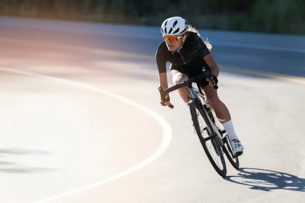 Ciclista ajustando uma meia de compressão de cano alto em fibra tecnológica