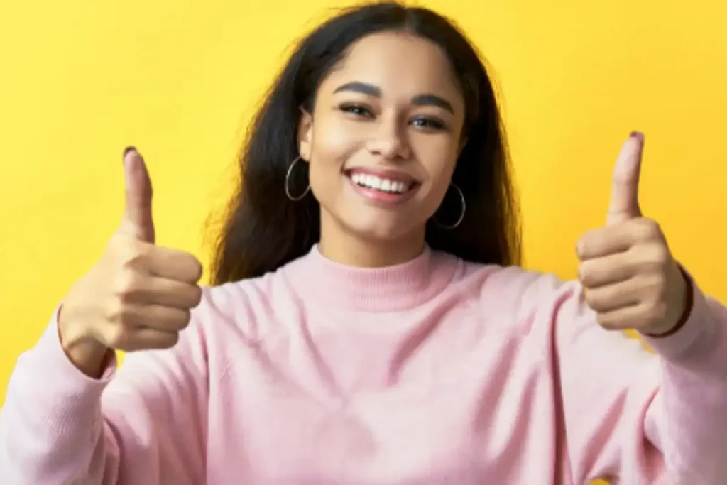 Foto de uma mulher sorrindo e acenando positivamente com a mão, em um gesto de confiança na compra segura do diploma
