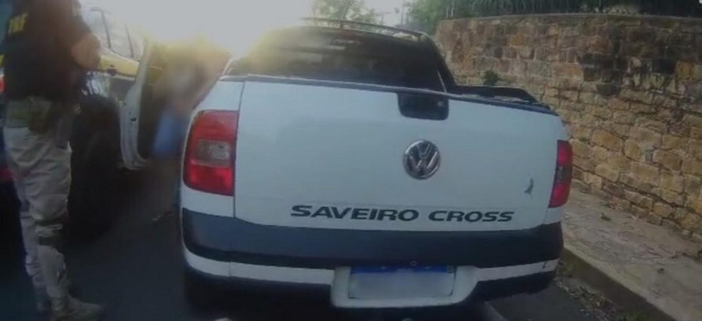 Agentes da Polícia Rodoviária Federal (PRF) abordam um veículo em uma via urbana, com viaturas da PRF ao fundo, em Piripiri.