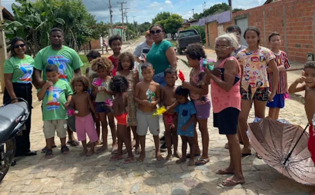Crianças sorrindo e recebendo ovos de chocolate da campanha Páscoa Crianças Felizes em São Pedro do Piauí.