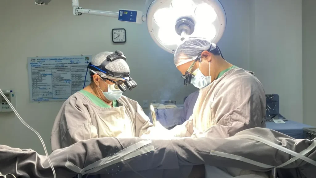 Equipe médica do Hospital Getúlio Vargas (HGV) em sala de cirurgia, realizando procedimento de coarctação da aorta.