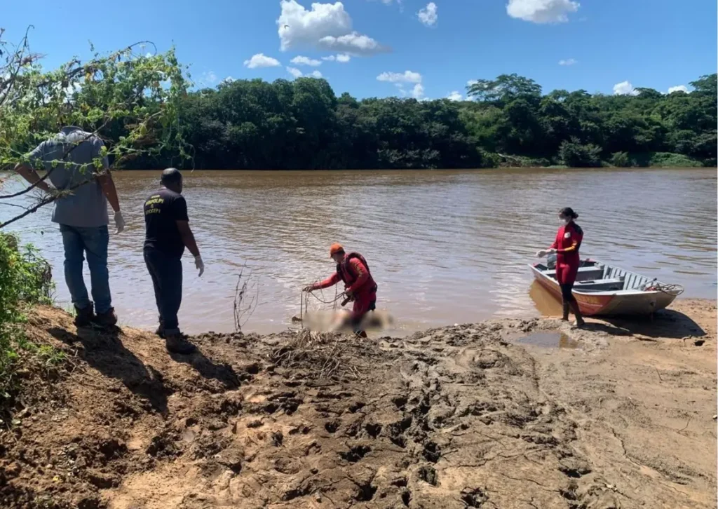 Militares do Corpo de Bombeiros em uma embarcação realizam buscas no Rio Poti durante operação de resgate de um corpo na zona Norte de Teresina.