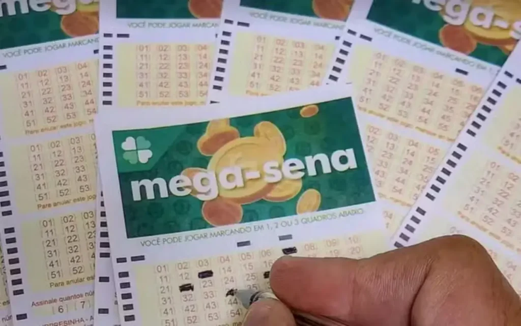 Mão de uma pessoa preenchendo um volante de aposta da Mega-Sena com uma caneta.