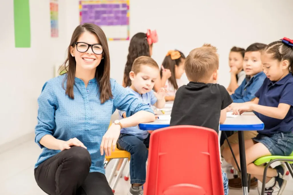Retrato de uma professora sorrindo e se divertindo com seus alunos da pré-escola durante uma atividade lúdica.
