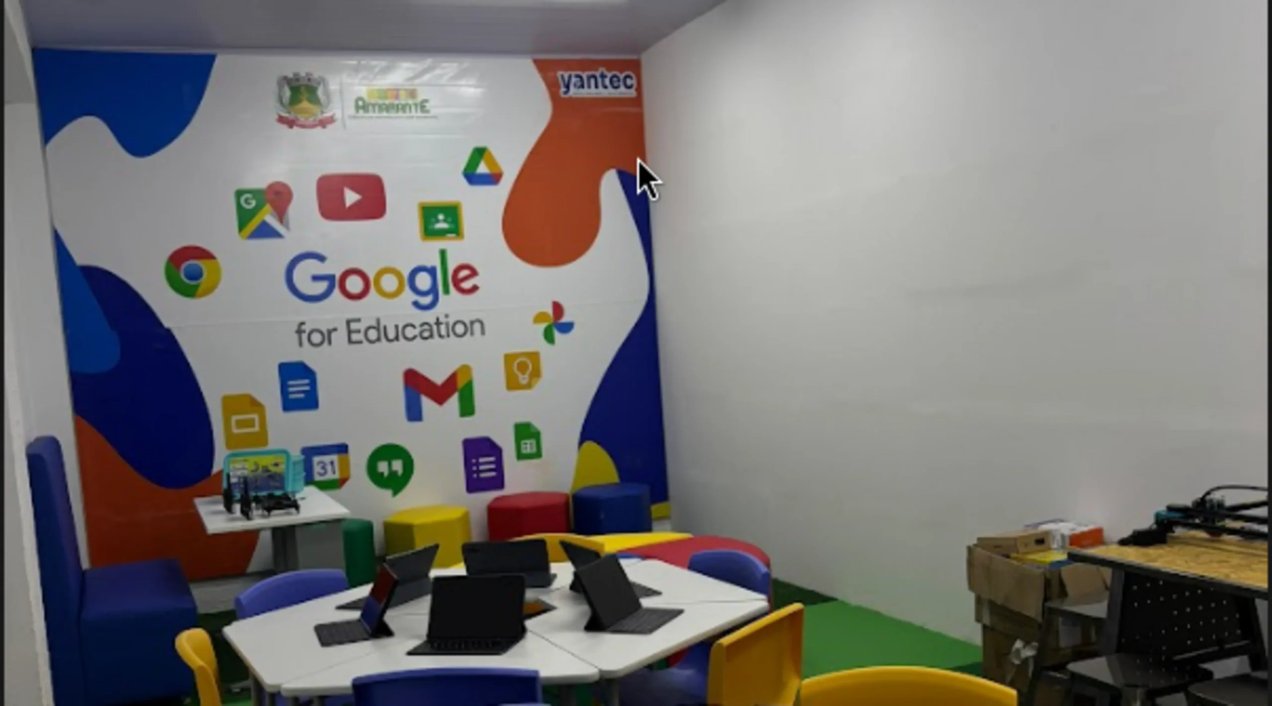 Escola municipal de Amarante recebe sala equipada com tecnologia Google 1 Sala de tecnologia educacional com mesas brancas, tablets, cadeiras coloridas e parede decorada com logos do Google for Education, incluindo Gmail, Google Drive, YouTube e Google Chrome, com a marca Yantec e o brasão do município de Amarante visíveis ao fundo