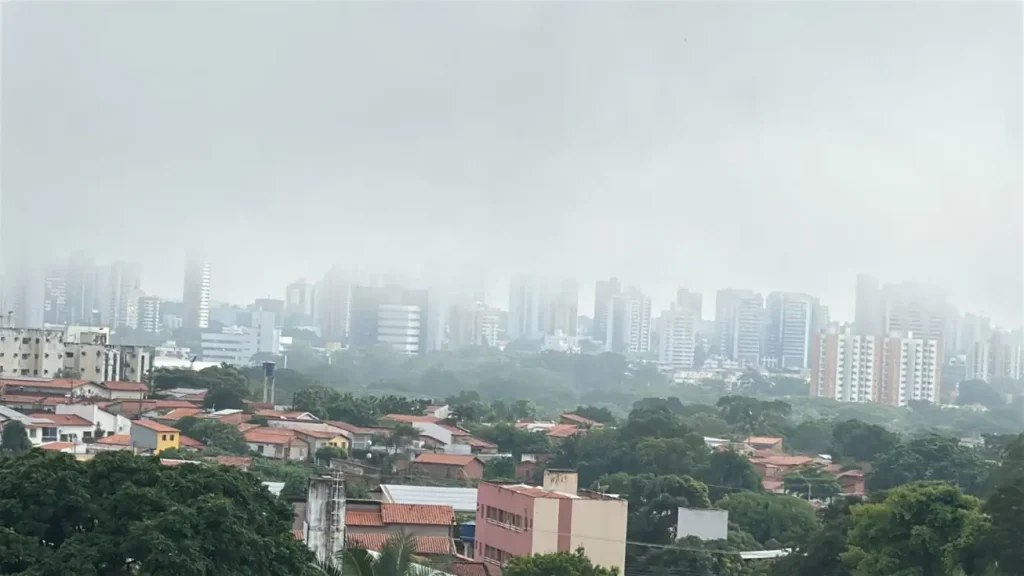 Neblina cobre Teresina e reduz visibilidade em avenidas e pontes nesta terça-feira 3 Vista panorâmica da cidade de Teresina com prédios e pontes parcialmente encobertos por uma densa camada de neblina durante o amanhecer.