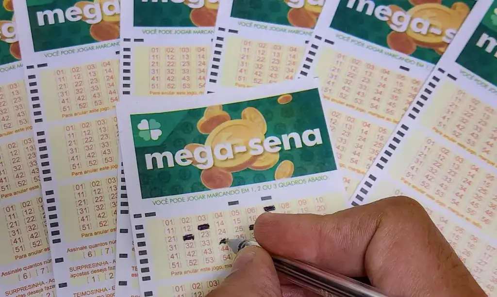 Mega-sena acumulada: Pessoa preenchendo bilhete da Mega-Sena com caneta