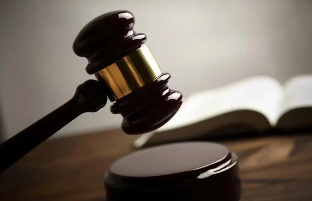 Homem condenado por matar mulher na br-010: Martelo de juiz sobre bloco de som em mesa