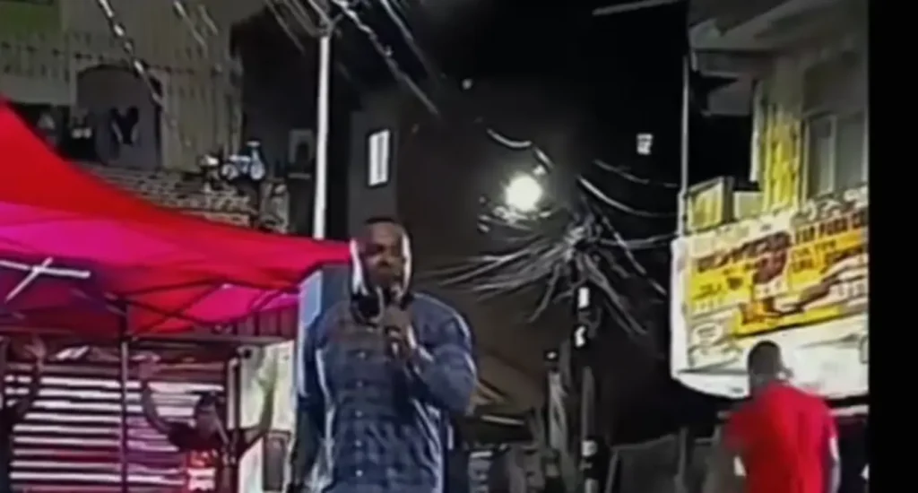 Rick Andrade da Silva, pastor executado em Salvador, discursa em evento noturno sob tenda vermelha.
