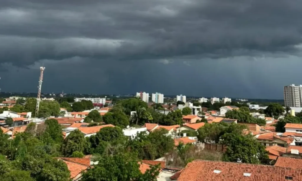 Chuvas no piauí durante fim de semana: Céu escuro com nuvens de chuva sobre telhados de casas
