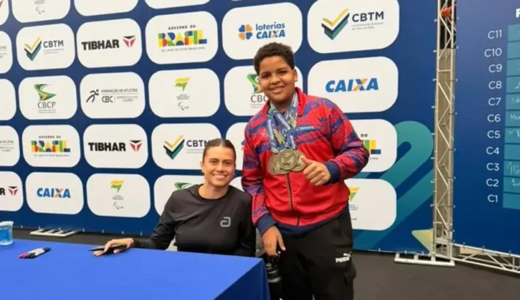 Israel Jr., de Oeiras, soma três ouros e um bronze no Brasileirão de Inverno de Tênis de Mesa 1 Israel jr. conquista ouro no brasileirão de tênis de mesa: Jovem atleta com medalhas posa ao lado de mulher