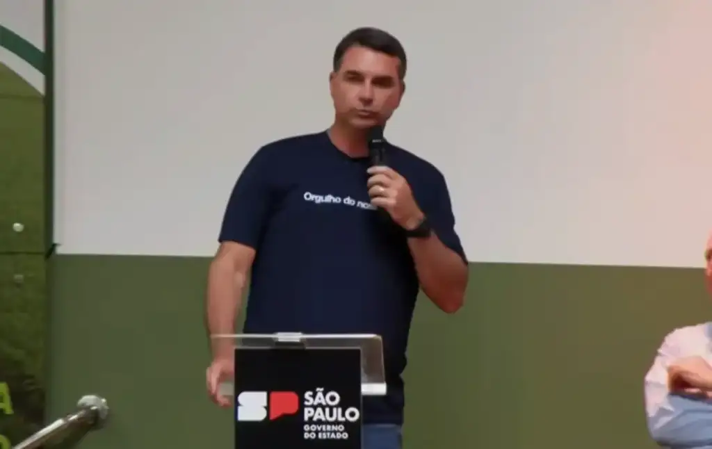 Flávio bolsonaro rebate lula sobre pcc e comando vermelho: Homem discursa em evento com logo do Governo de São Paulo