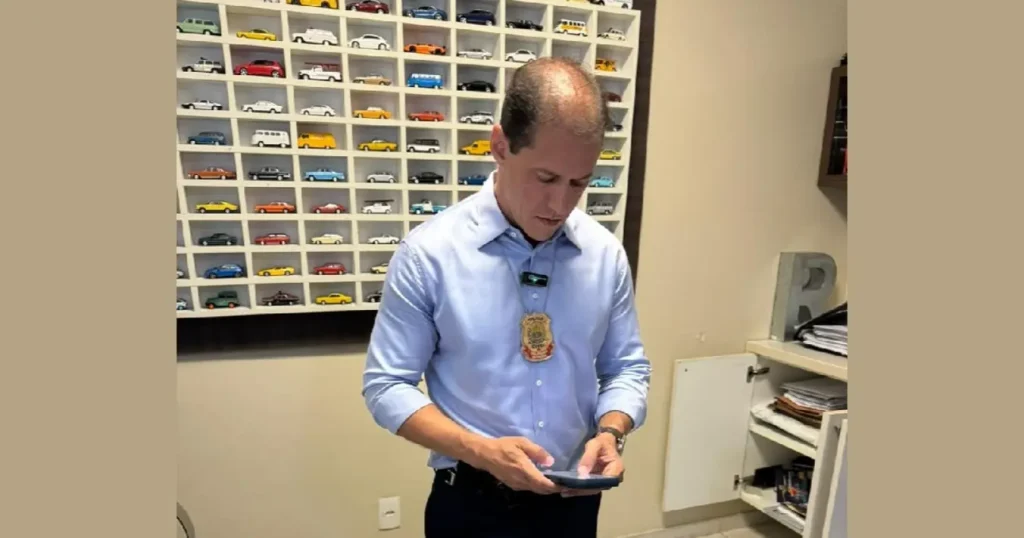 Empresário preso por golpe com veículos em teresina: Delegado olhando celular em escritório com miniaturas