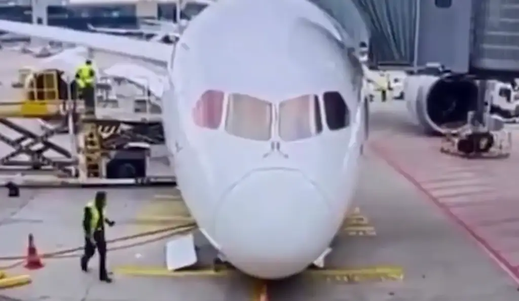 Avião branco estacionado no aeroporto com equipe de solo