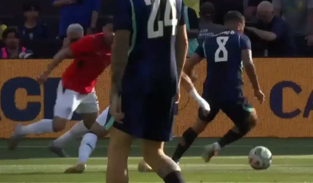 Jogadores de futebol disputam bola em campo gramado