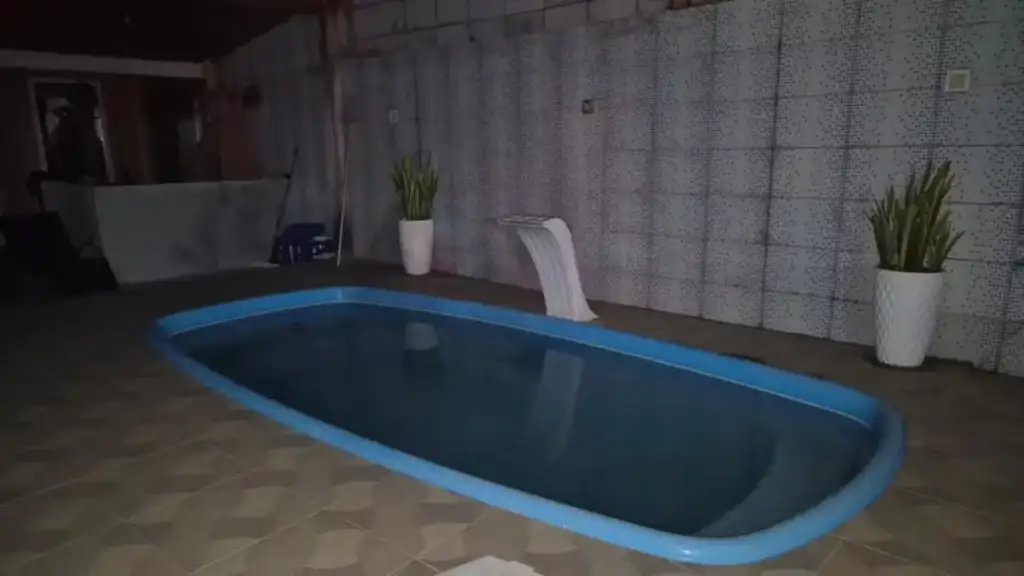 Piscina interna com cascata e plantas em vasos