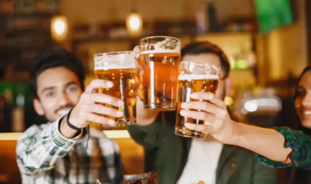Grupo de amigos fazendo um brinde com canecas de cerveja em um bar