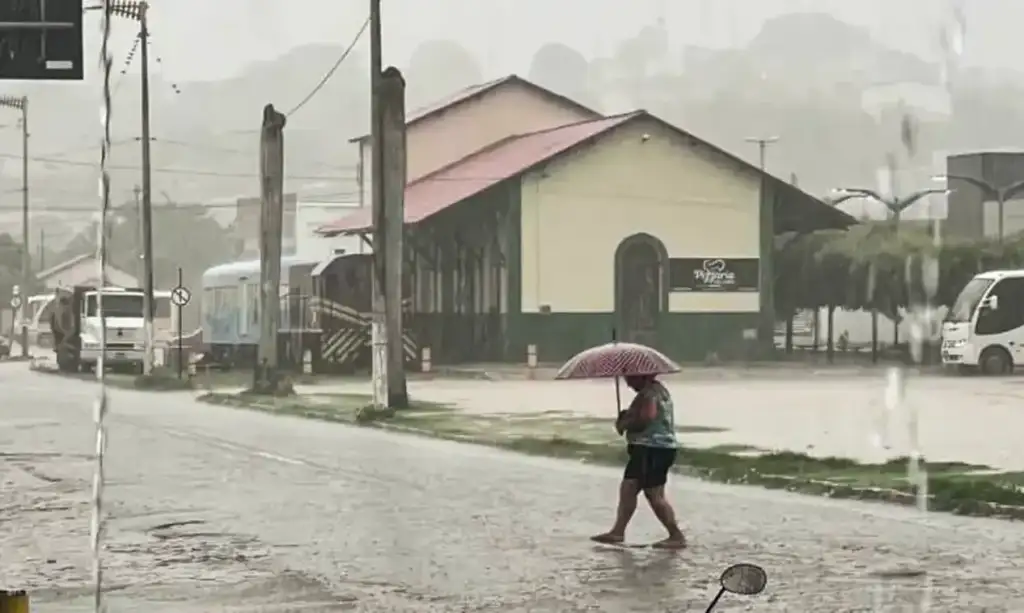 Alerta de chuvas intensas no piauí e maranhão: Pessoa com guarda-chuva em rua alagada no Piauí