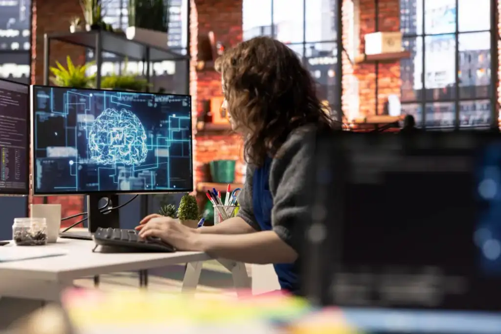 Mulher trabalhando em computador com imagem de cérebro digital representando inteligência artificial na tela
