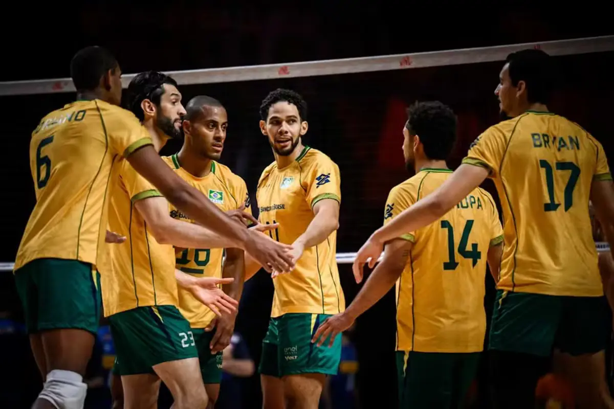 Jogadores da seleção brasileira de vôlei masculino se cumprimentam em quadra durante partida