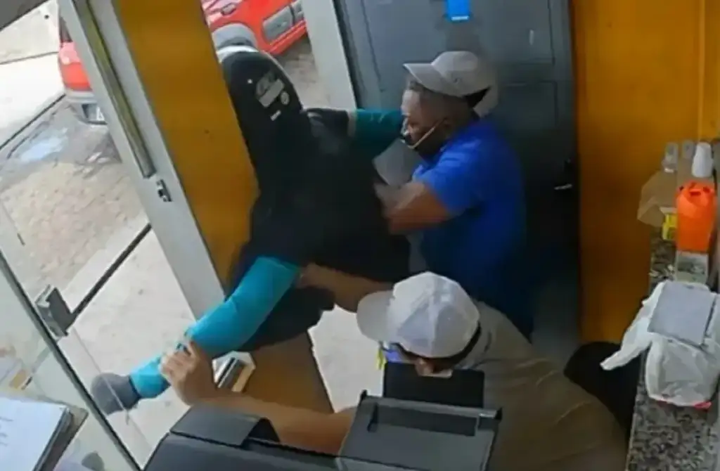 Imagem de câmera de segurança mostra homens em confronto físico dentro de um estabelecimento, com uma pessoa sendo erguida durante a briga