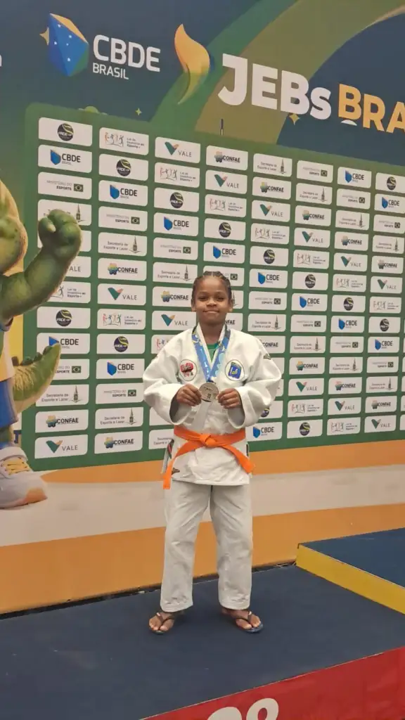 Davy de Jesus de judogi, exibindo a medalha de prata no pódio dos Jogos Escolares Brasileiros