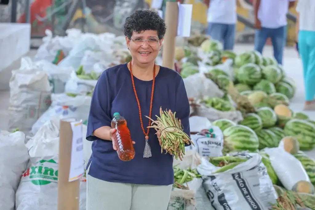 Distribuição de alimentos em teresina: Mulher exibe alimentos da agricultura familiar em Teresina