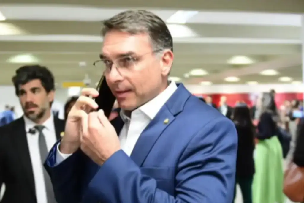 Flávio bolsonaro lidera oposição de miami: Flávio Bolsonaro ao telefone liderando oposição de Miami